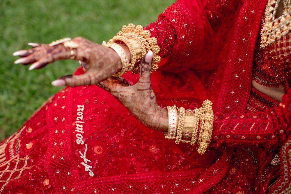 Photo of Bride flaunting her unique bridal bangles and customized dupatta with her wedding date embroidered on it.
