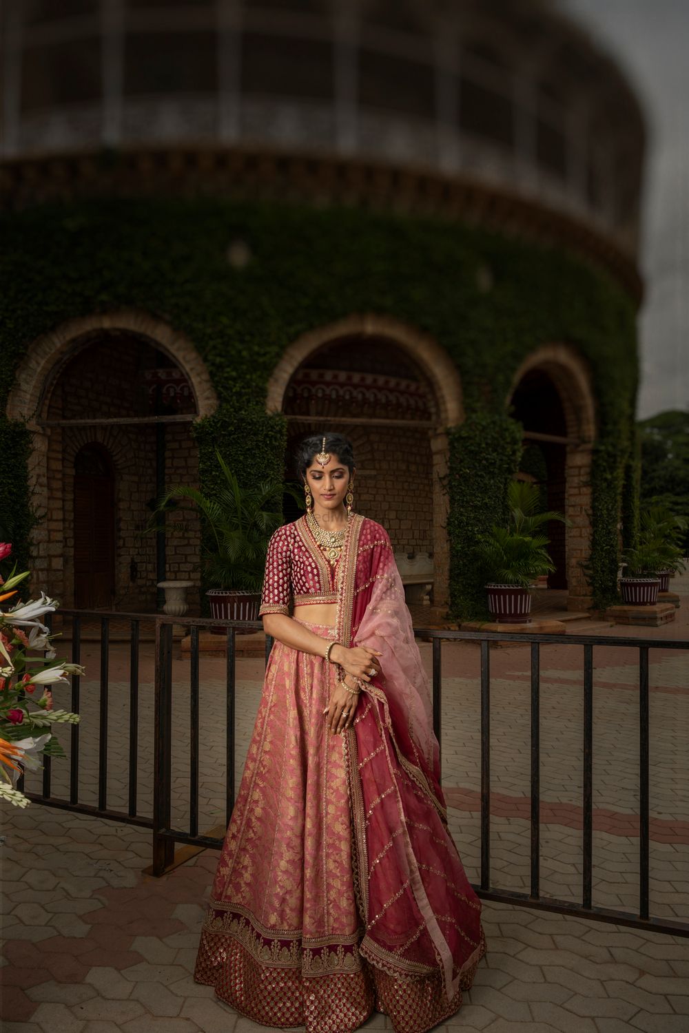 Photo of A sister of the groom posing in a red lehenga