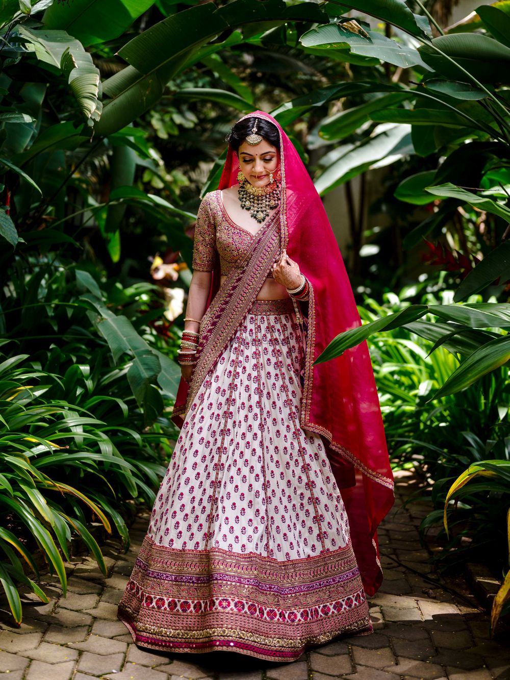 Photo of Bride dressed in an ivory and red bridal lehenga,