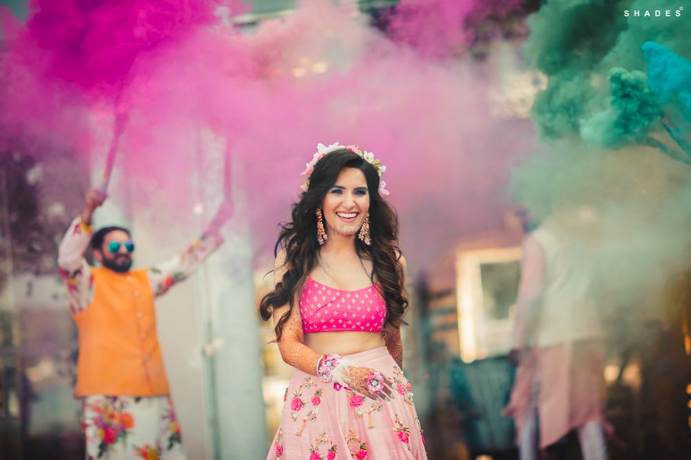 Photo of A bride in a pink outfit entering with smoke bombs for her mehndi ceremony