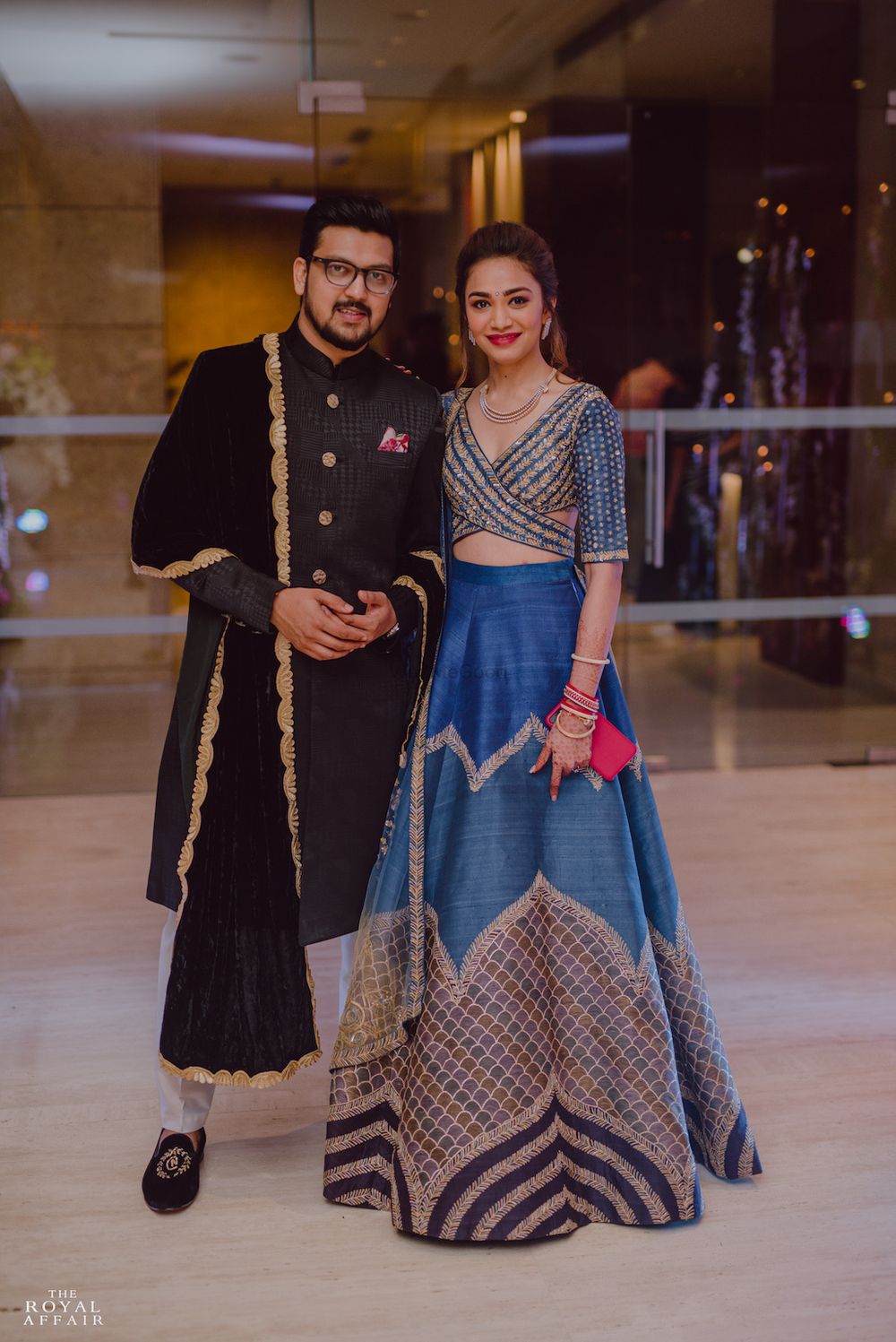 Photo of A bride and groom pose on their sangeet nigh