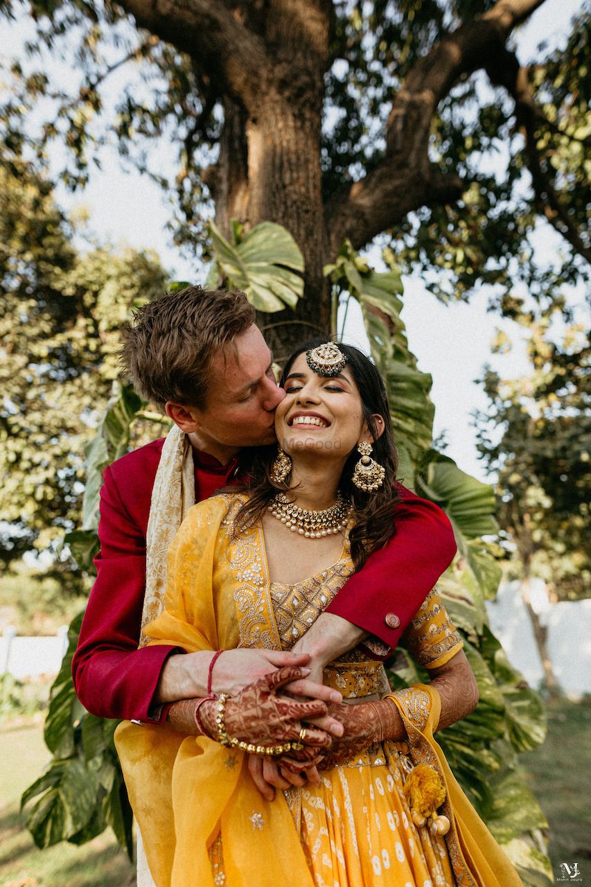 Photo of Groom kissing the bride at their mehendi function.
