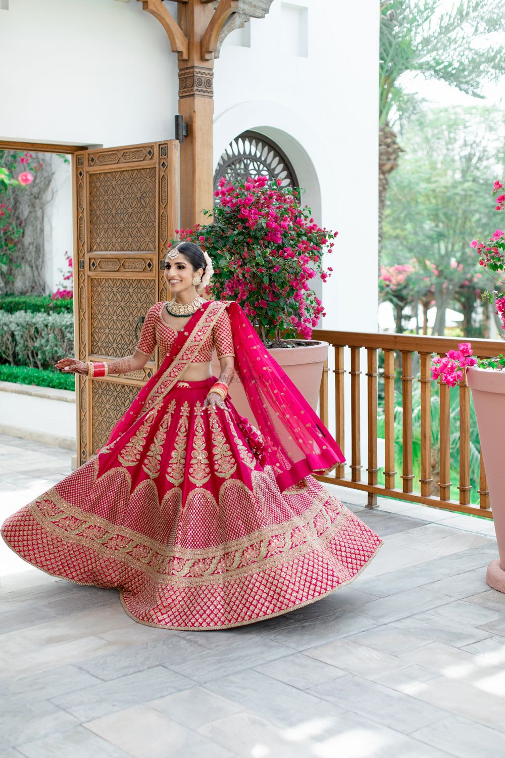 Photo of Bride twirling in her bright pink lehenga.