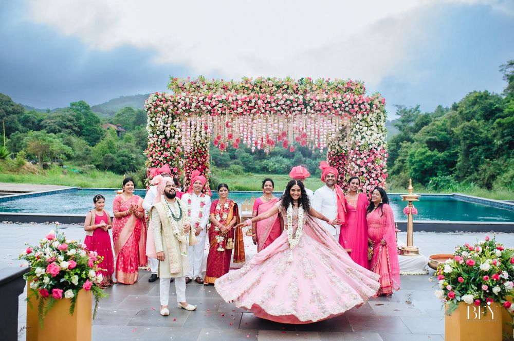 Photo of twirling bride shot with family in front of mandap