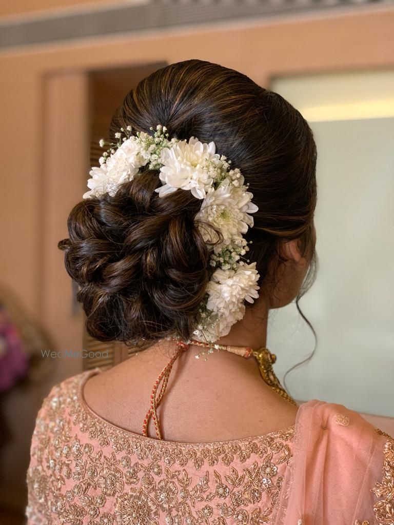 Photo of A twisted bridal bun outlined with white flowers.