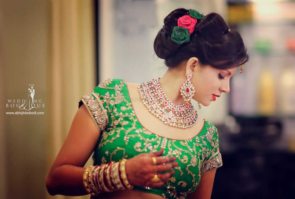 Photo of Bridal bun with green and red fabric roses