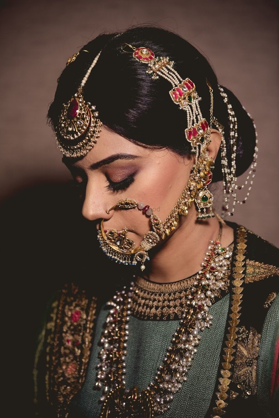 Photo of A bride with heavy jewelry, mangtikka an nath. d