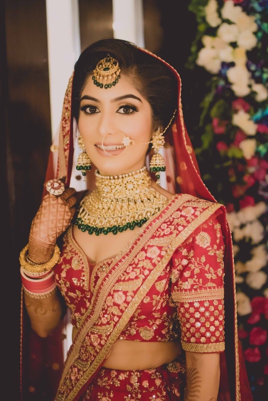 Photo of Bride in red with green contrasting jewellery