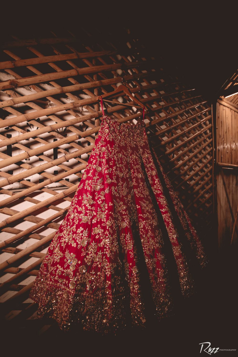 Photo of red and gold simple bridal lehenga on hanger