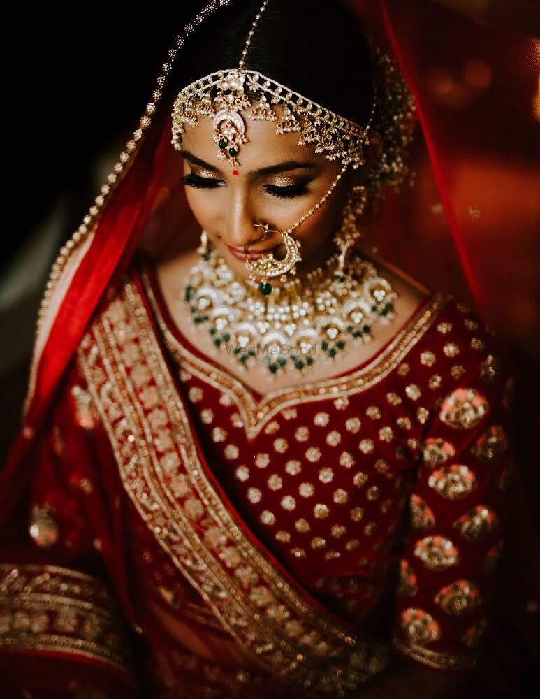 Photo of A pictures of a bride in maroon lehenga and beautiful jewellery.