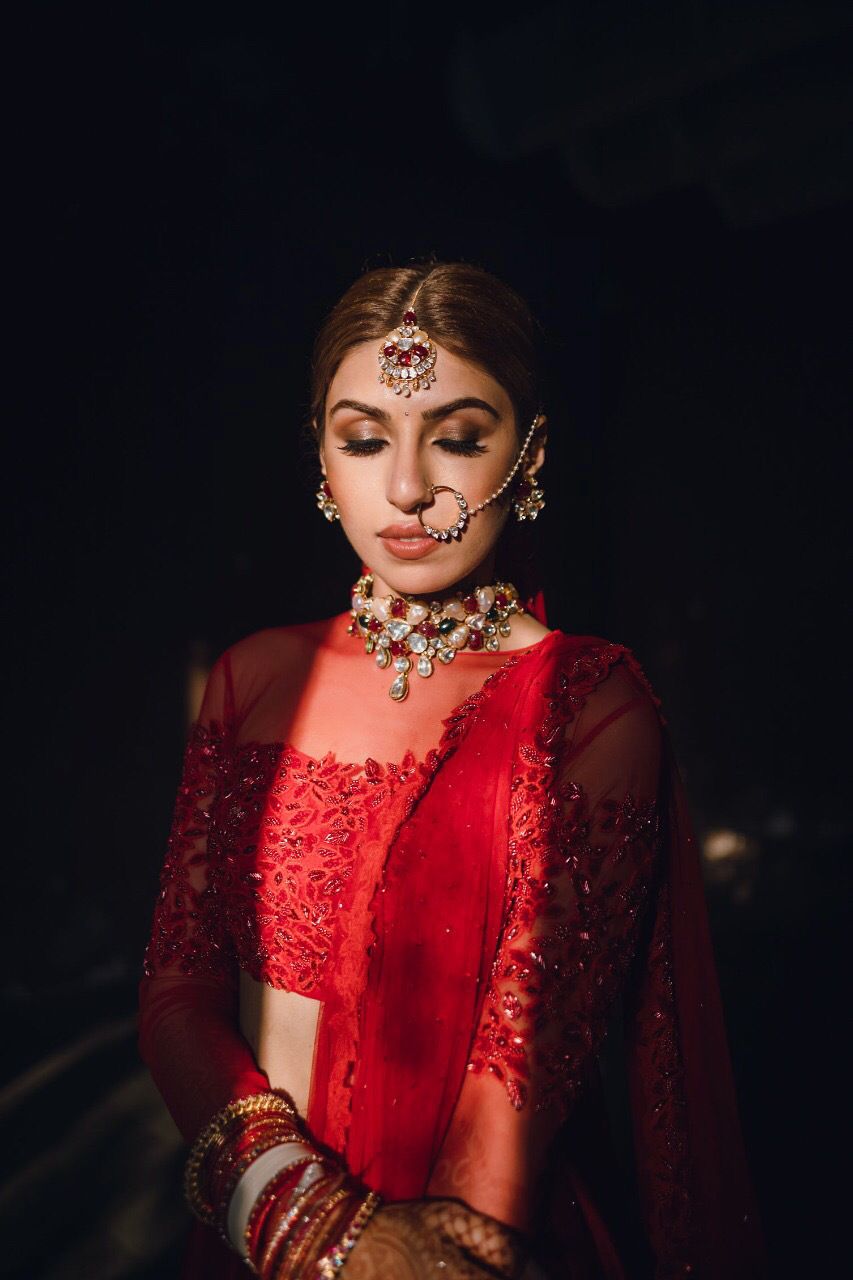 Photo of Bride dressed in a red lehenga on her wedding day.