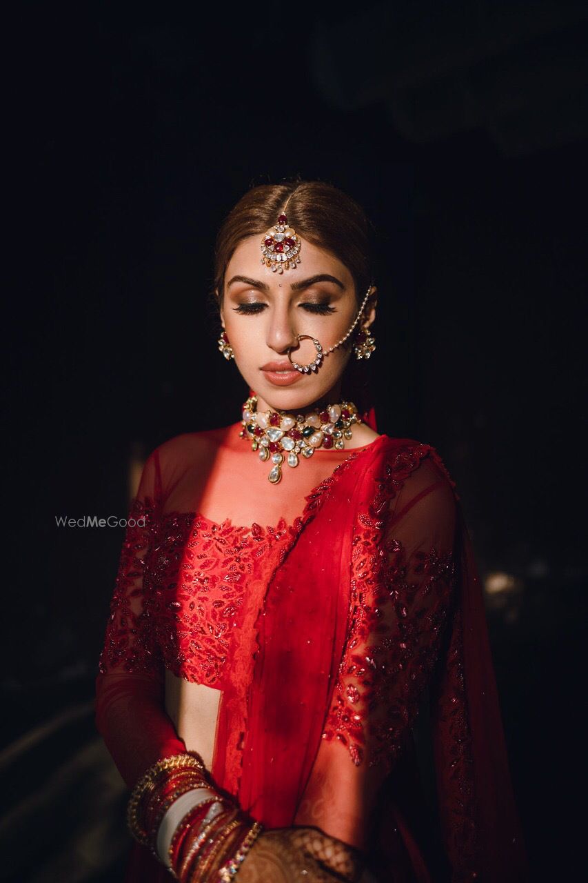 Photo of Bride dressed in a red lehenga on her wedding day.