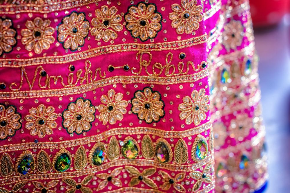 Photo of Bright pink lehenga with couple's names embroidered