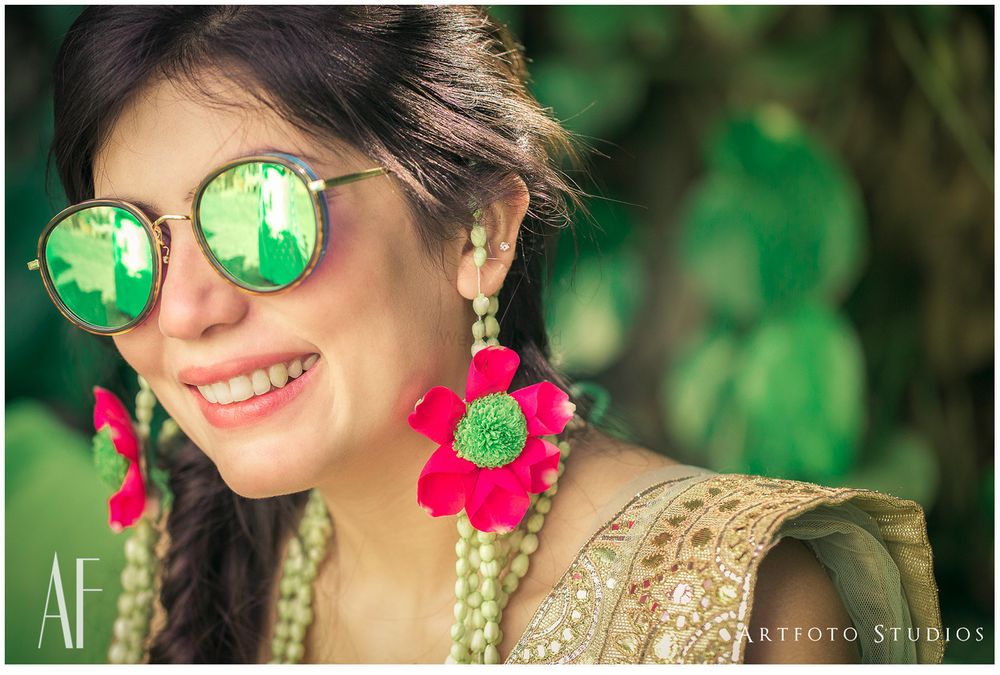 Photo of Bride in green reflector sunglasses on mehendi