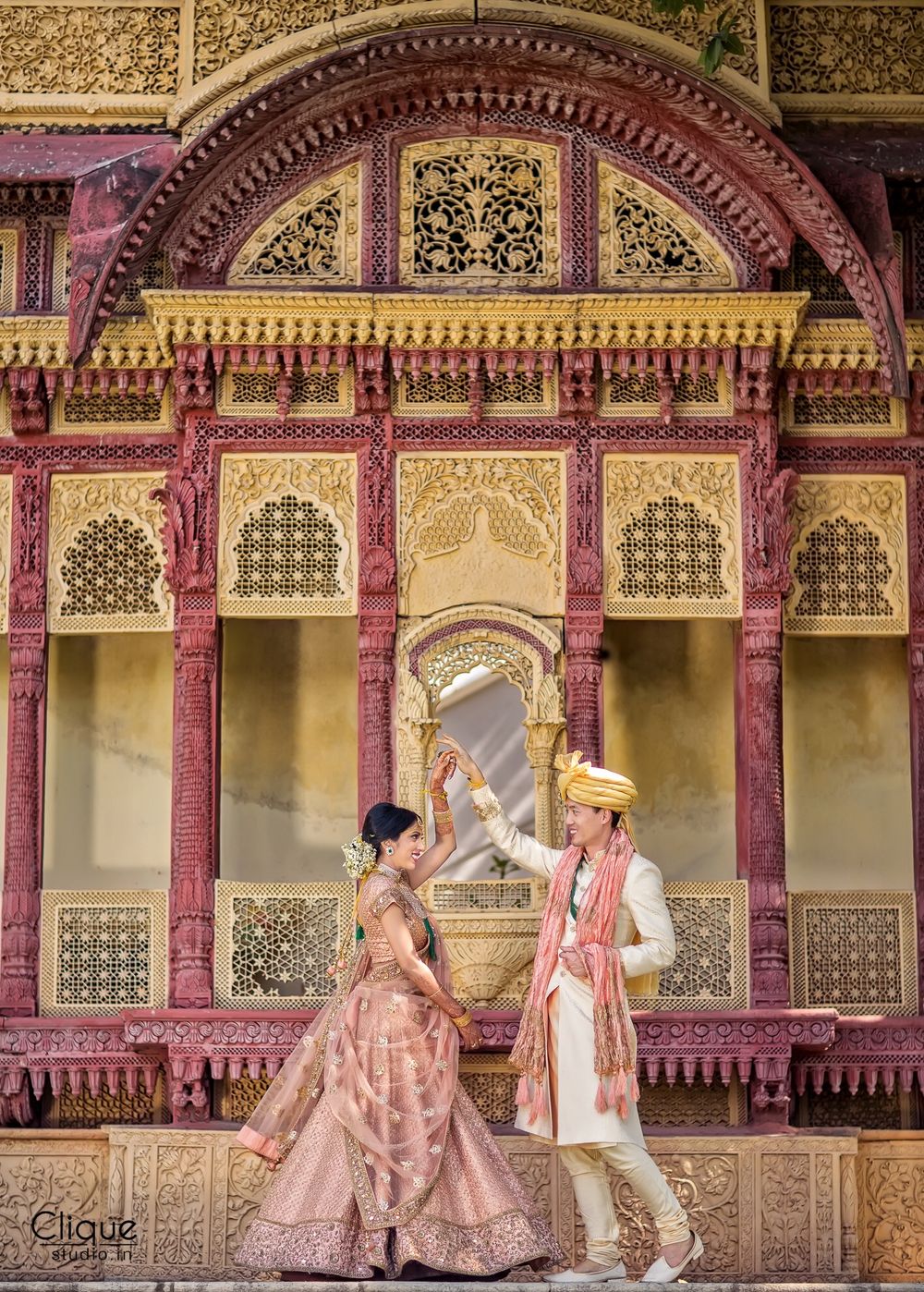 Photo of Destination wedding couple portrait at palace in coordinated outfits