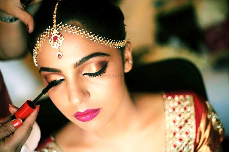 Photo of Bridal makeup with gold eyes and bright pink lips and mascara