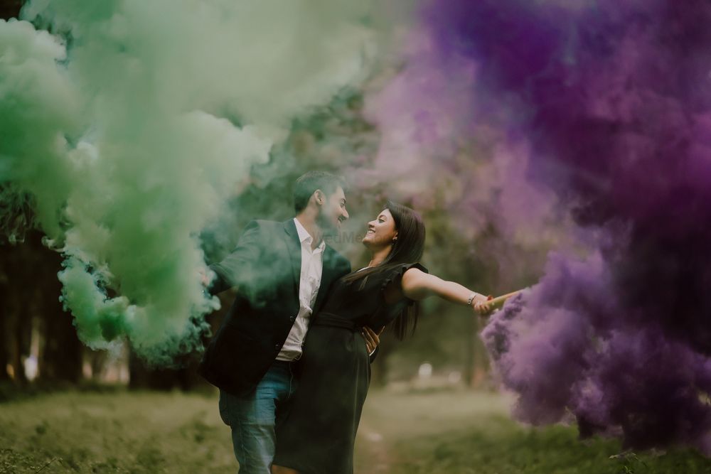 Photo of pre wedding shoot with couple holding smoke sticks