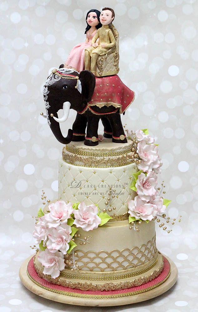 Photo of Gold destination wedding cake topper with couple on elephant