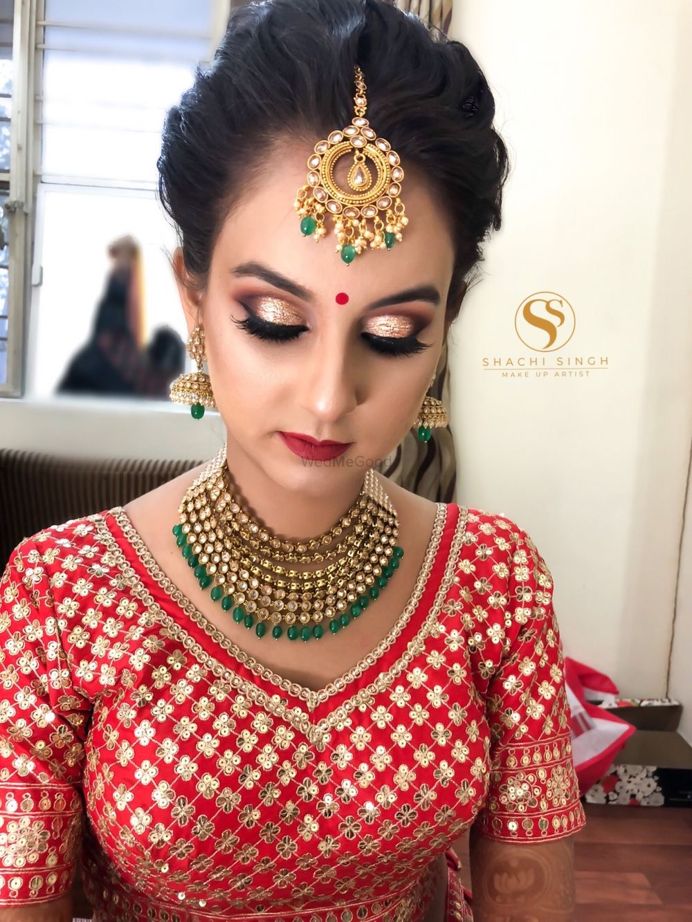 Photo of Pretty bride in red embroidered blouse with gold jewelry