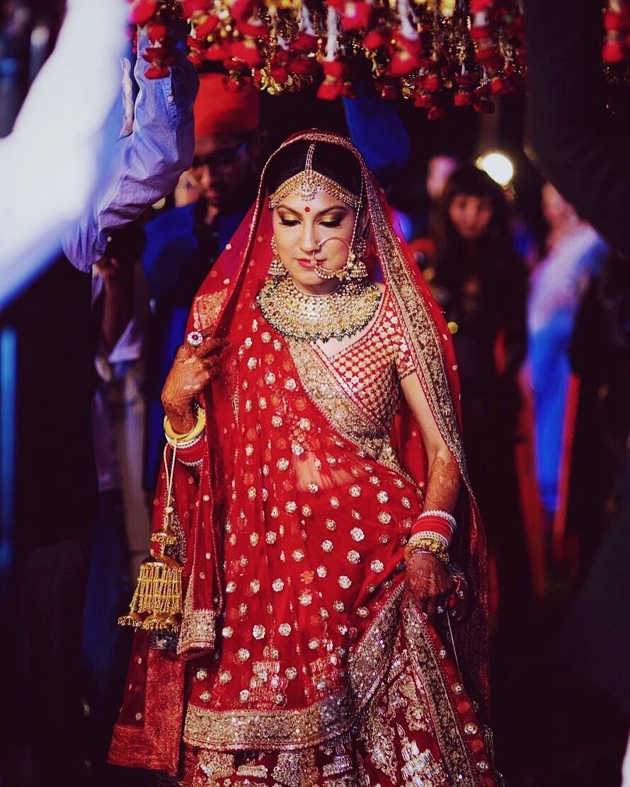 Photo of Bride in red lehenga entering wedding