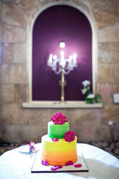 Photo of Colourful wedding cake with different layers and flowers