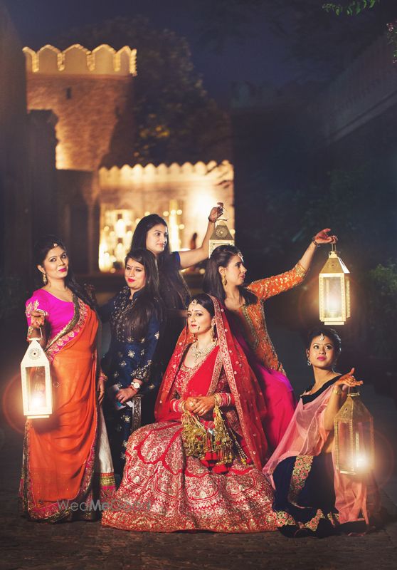 Photo of Bride with bridesmaids holding lanterns