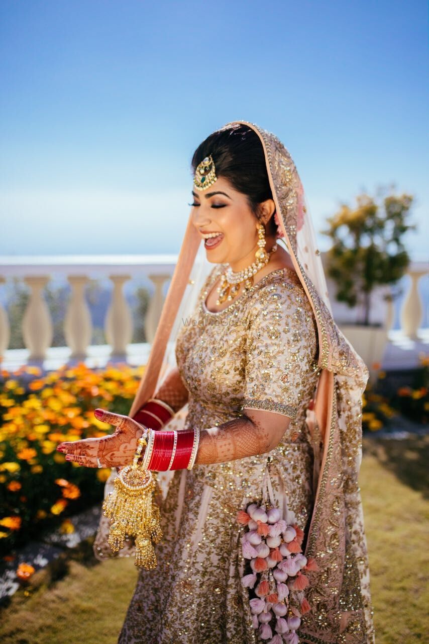 Photo of Bride in beige lehenga with unique kaleere and tassels