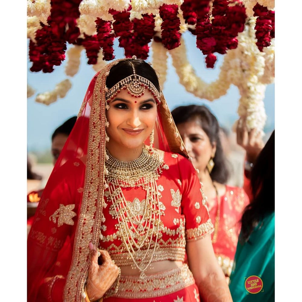 Photo of A bride in red lehenga and gold jewelry