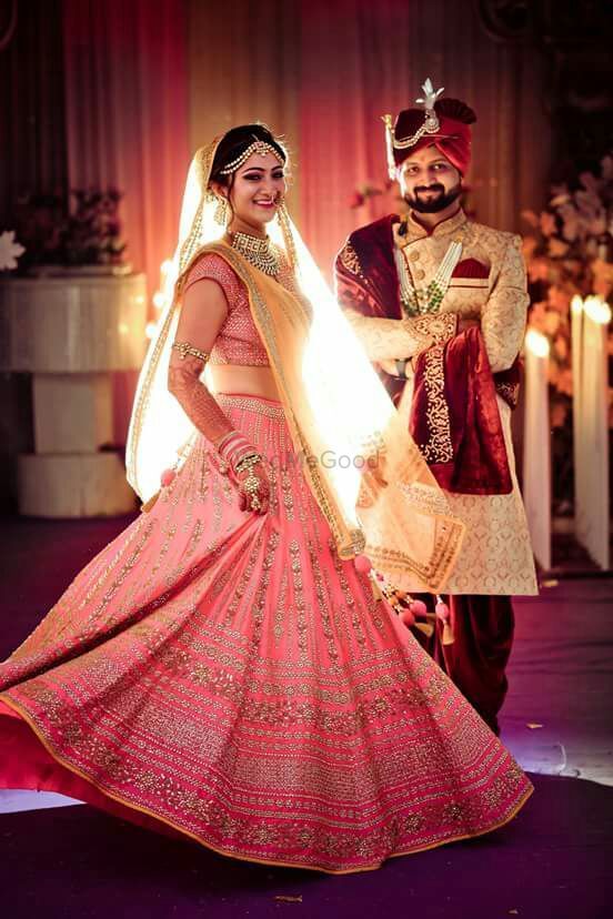 Photo of Cute twirling bridal shot with a baby pink lehenga