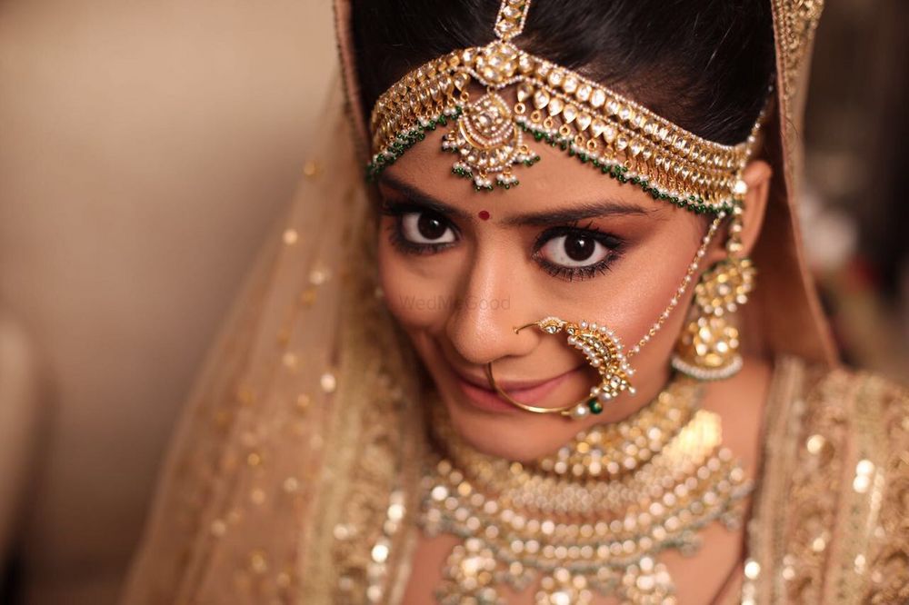 Photo of Gold statement mathapatti and vintage bridal nath