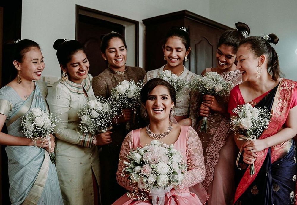 Photo of Bride with her bridesmaids holding the bouquet.