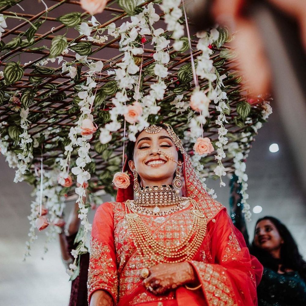 Photo of A happy bride under phoolon ki chadar.