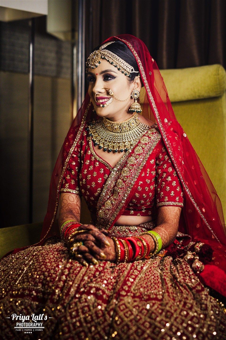 Photo of A bride in a red lehenga and gold jewelry for her wedding