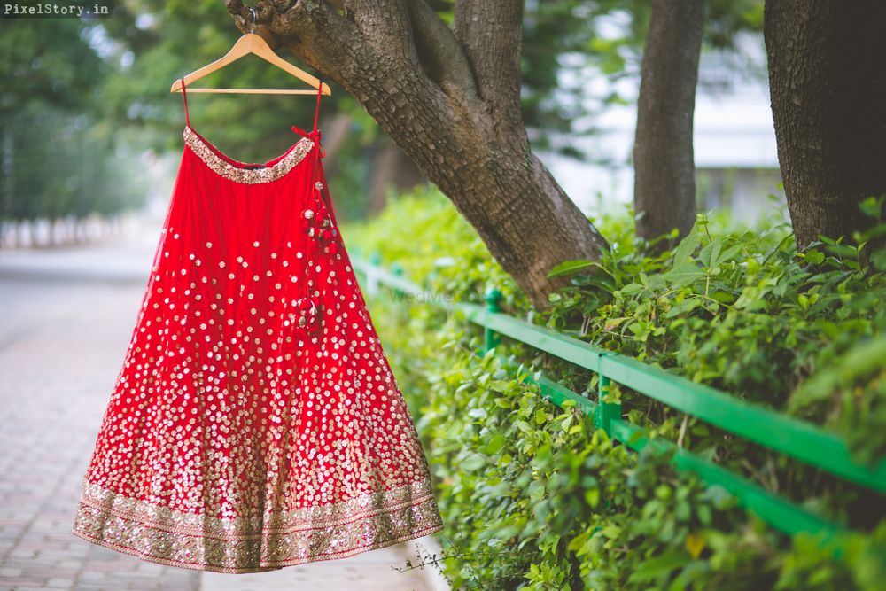 Photo of Red Bridal Lehenga with Gold Sequins on a Hanger