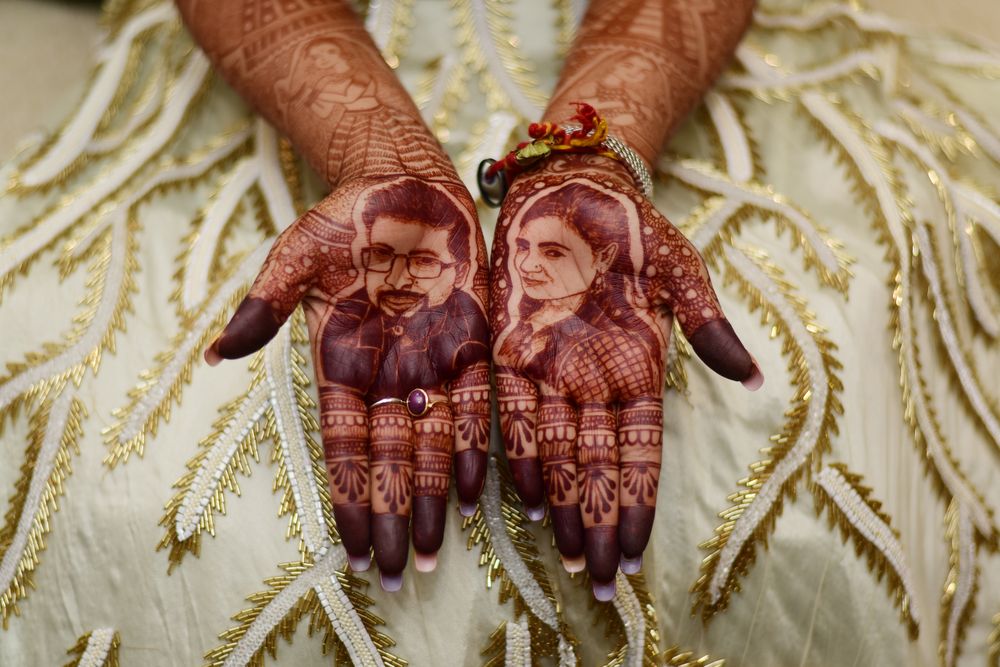 Photo of Mehendi with realistic bride and groom portraits