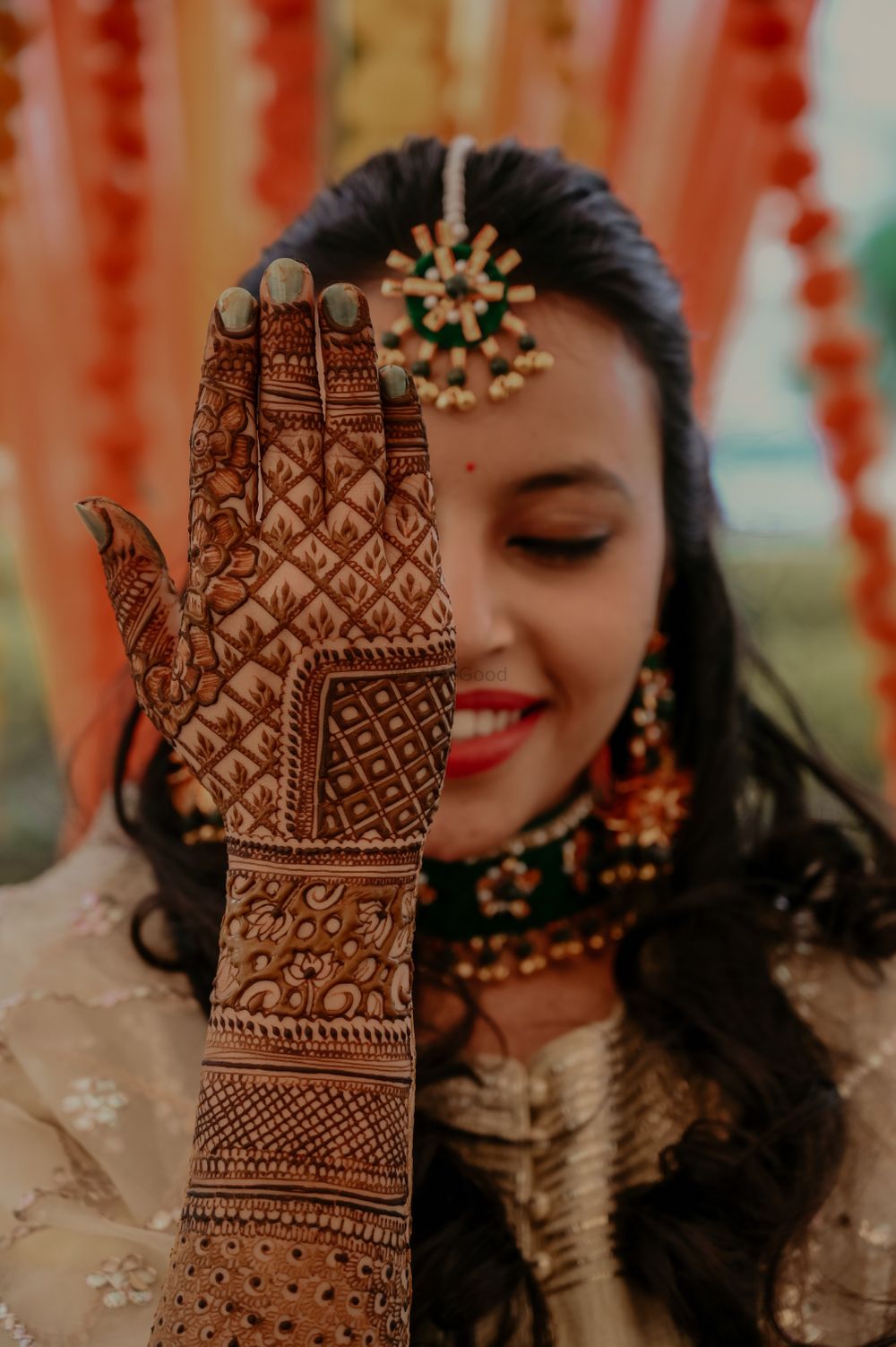 Photo of Bride showing off her back hand mehndi design.