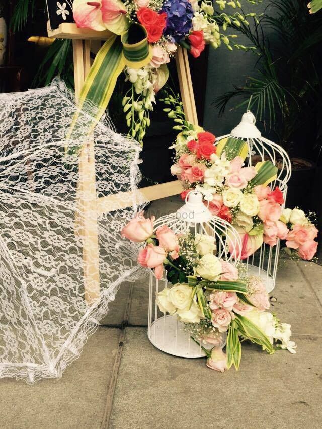 Photo of Cute floral arrangements with umbrella and birdcages