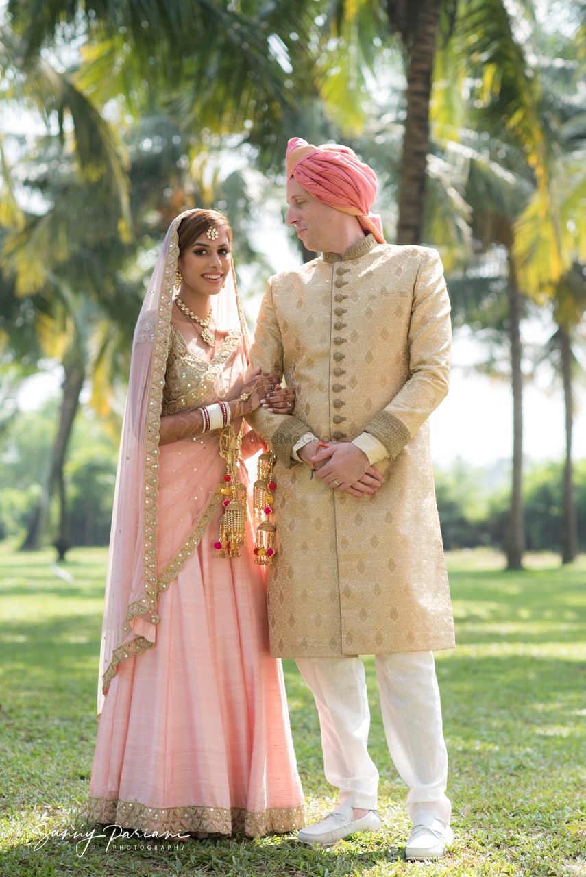 Photo of morning wedding couple with bride in light pink and groom in beige sherwani
