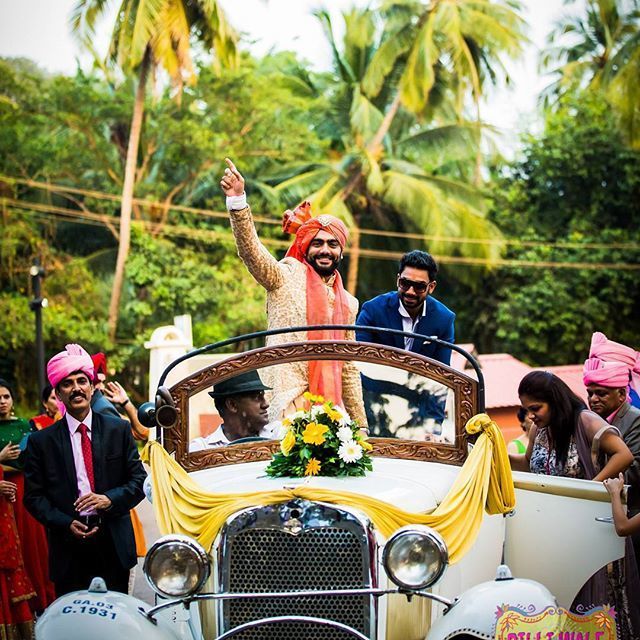 Photo of Groom entry in a white vintage car