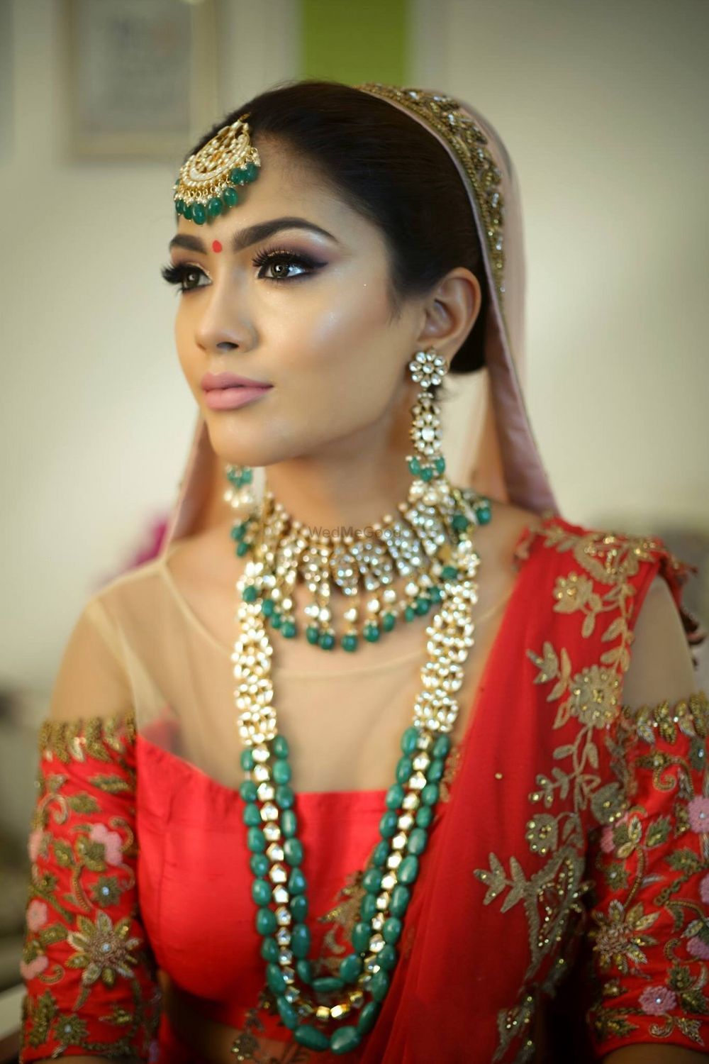 Photo of Bride with nude makeup and dark green jewellery with beads