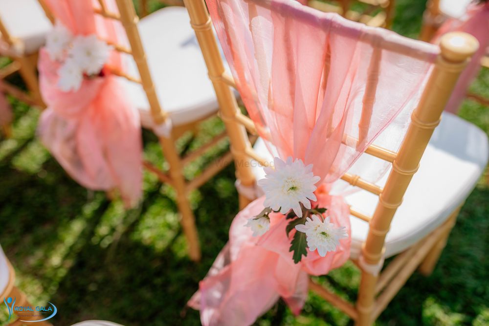 Photo of Chair backs decorated with peach drapes and flowers.