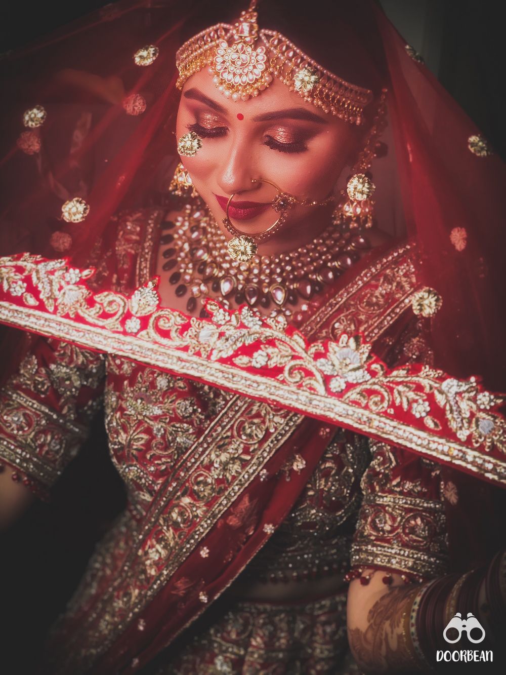 Photo of A coy bride in a maroon lehenga