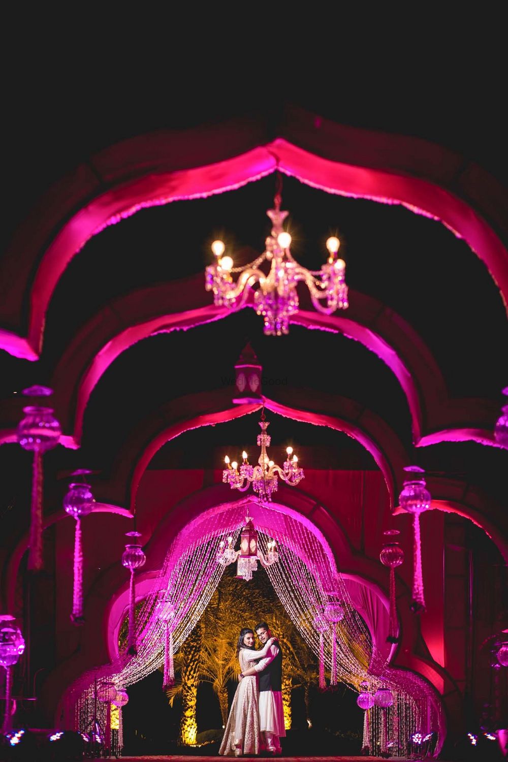 Photo of Beautiful shot of a couple standing in a line of archways