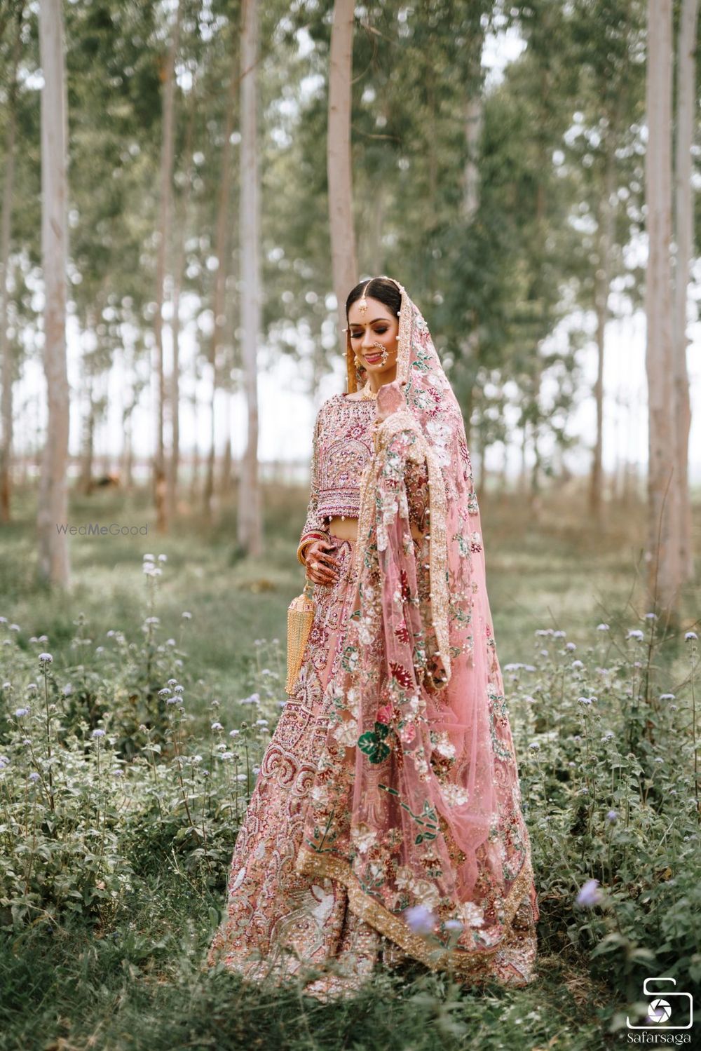 Photo of Bride wearing a fully embellished pink bridal lehenga.