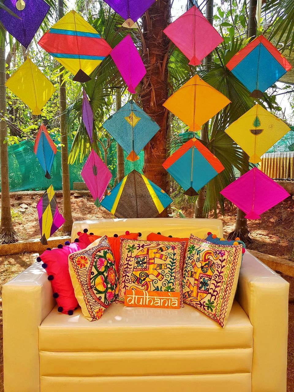 Photo of Mehendi decor idea for bridal photobooth with kites and cushions