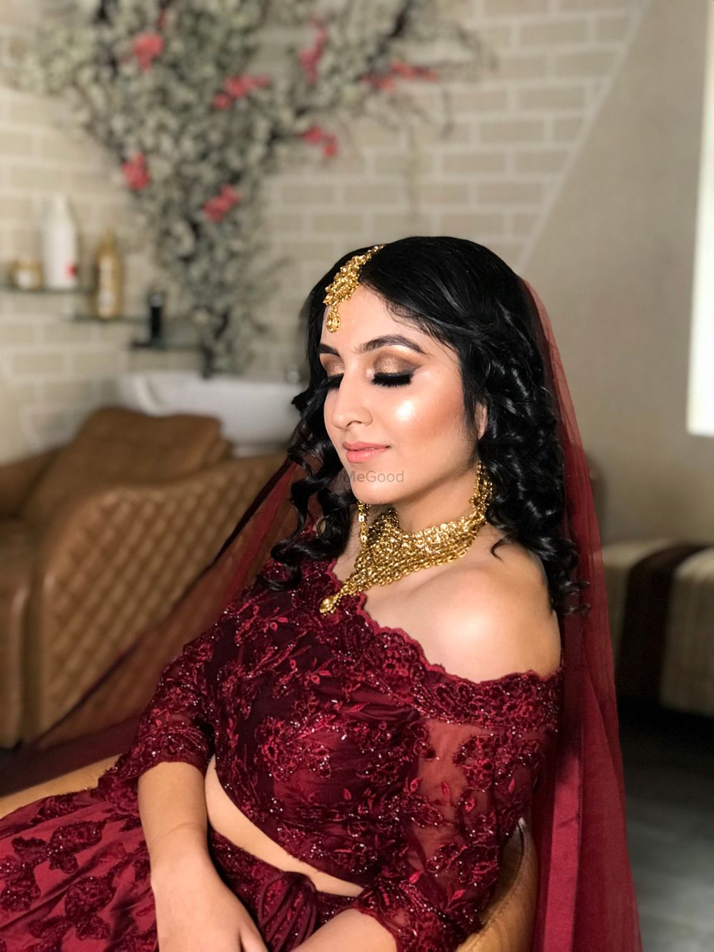 Photo of A beautiful bridal makeup in maroon off-shoulder lehenga.