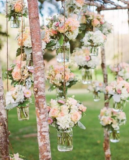 Photo of Peach and white flowers in mason jars for engagement decor