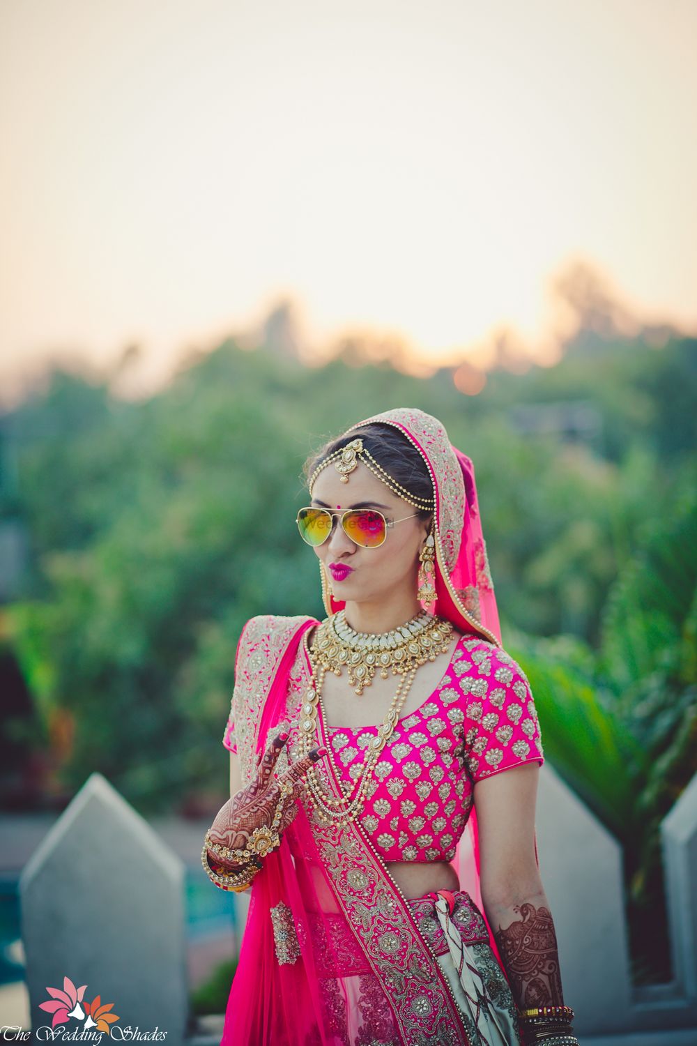 Photo of Cool bride in reflector sunglasses wearing pink lehenga
