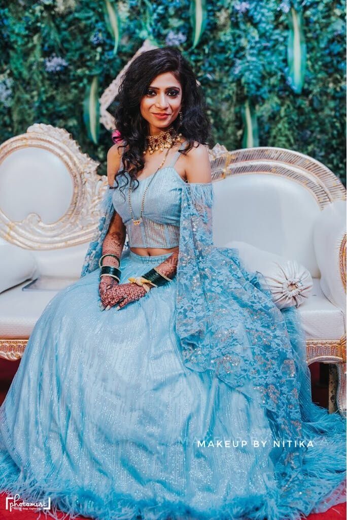 Photo of Engagement lehenga in light blue with cape sleeves cold shoulder