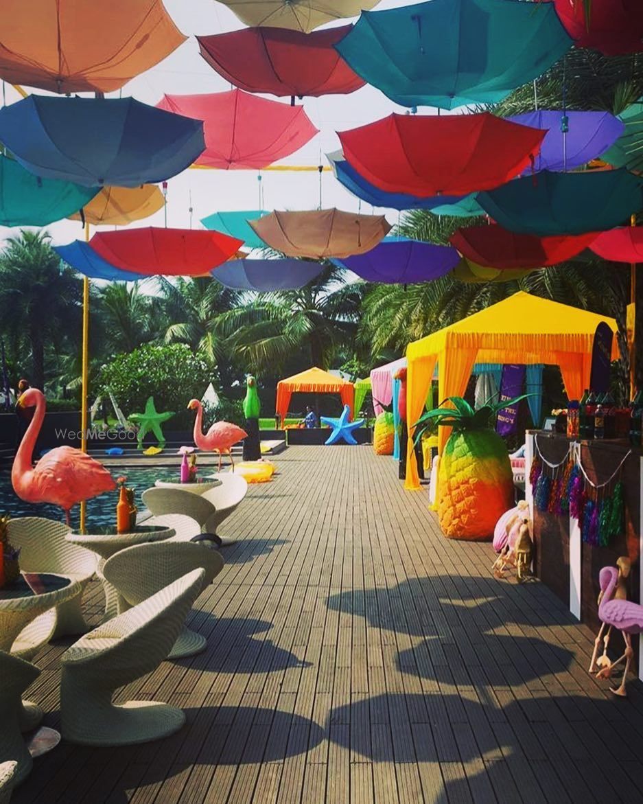 Photo of Tropical theme mehendi decor with hanging parasols